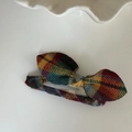 Detail view of vintage plaid bow hair clip with colorful yellow and blue tartan pattern - Blue Red Stripe Bow Hollow Water Drop Clip
