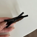Detailaanzicht van een bruin geweven haarklem met strik en zwarte lederen accenten - Ovale Strik Stijl / Khaki Ovale Clip met Zwarte Strik