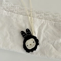 Close-up of handmade cartoon plush necklace with black wave edge and cream fabric - Black Ear Rabbit Lanyard