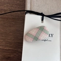 Nahaufnahme einer rosa-grün karierten Stoff-Haarklammer auf einem Holztisch - Pink-Grün Gestreift