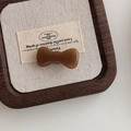 Detalle de pinza de pelo de lazo caramelo con grabado France Hand Made en acetato - Marrón Caramelo