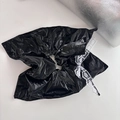 Dettaglio di un grande scrunchie in ecopelle nera lucida con fiocco in pizzo bianco - Stile Aquilone Nero