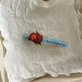 Nahaufnahme der Haarspange aus Acryl mit blauem Karomuster und roten Erdbeeren-Motiv - Bayberry Blau