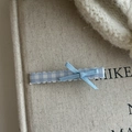 Detailansicht der hellblauen karierten Haarspange mit zarter Bandschleife auf Stoff - Blau Weiß Gingham Blau Schleife Set