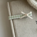 Detailed close-up of a green plaid ribbon hair clip with a bow on a creamy canvas backdrop - Green White Gingham White Bow Set