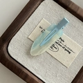 Detail einer blauen durchsichtigen Haarspange aus Harz mit Glitzer auf Leinen - Nahtlose Clip / Hellblau
