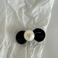 Fermaglio per capelli a fiocco nero con perla bianca sintetica su sfondo di carta bianca - Fermaglio Capelli Fiocco Nero Perla Bianco Crema