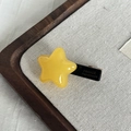 Handmade yellow star-shaped acetate hair clip on a wooden tray for women - Yellow