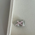 Detail of grey oval hair clip with textured surface and pink ribbon bow on canvas - Gray Clip Pink Bow