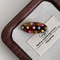 Barrette ovale en écaille de tortue à pois colorés sur un fond en lin texturé - Pince ovale écaille de tortue points colorés