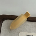 Close-up of matte translucent yellow duckbill hair clip on a neutral background - Ginger Yellow