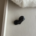 Detailed macro view of heart-shaped hair clip with vintage beige polka dots on black base - Black White Dot Heart Clip
