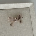 Détail d'une pince à cheveux avec nœud à pois doux sur un plateau de bijoux minimaliste - Pince à Cheveux Nœud Champagne