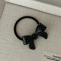 Detailed macro shot of a black polka dot bow elastic hair tie on a neutral background - Black Bowknot Hair Tie