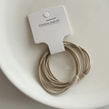 Coleteros elásticos multifilamento beige sobre un plato de cerámica blanca - Color Té con Leche