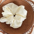 Elegant cream white satin scrunchie with pleated texture and subtle brand label detail - White Large Satin Style