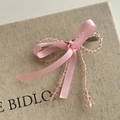 Dettaglio di fermaglio per capelli con fiocco rosa e perline trasparenti su scatola - Fiocco Rosa Clip Cristallo Rosa