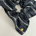 Détail d'un chouchou rayé bleu marine avec un charmant pendentif en cœur doré gravé - Chouchou à Rayures Noires