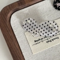 Detailed macro view of polka dot hair clip with silver rhinestone bows on linen - White Heart Black Polka Dot White Crystal Bow