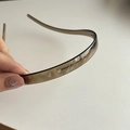 Detail shot of the brown transparent hairband with anti-slip teeth and brand logo - 1# Transparent Champagne Headband