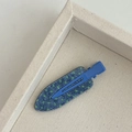 Detailansicht einer blauen Haarspange mit Jeansmuster und grünen Punkten auf einem grauen Tablett - Grün Punktmuster Denim Textur