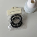 Zweiteiliges Set rauchgrauer Spiral-Haargummis in transparenter Verpackung mit Karte - Set mit schwarzen Zirkonia