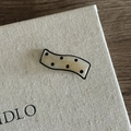 Close-up of wavy cream hair clip with black polka dots and a pearlescent acetate texture - Cream Striped Black Polka Dot Style