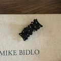 Dettaglio di un fermaglio per capelli ondulato nero con pois bianchi su carta - Stile Quadrato a Pois Bianchi Nero