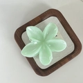 Close-up of mint green plumeria flower hair claw clip with smooth resin finish - Green Floral Hair Claw