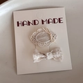 Détail de barrettes à fleurs en dentelle crème fait main et ensemble de nœuds élégant - Blanc Cassé Texture Ovale