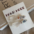 Gros plan de barrettes en acrylique nacré avec motifs ours et fleurs sur carte - Style Fourchette Personnage Bleu Boule Blanche