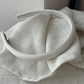 Close-up of cream textured satin headband with delicate fabric detail and black lining - Narrow Side / White