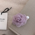 Detailansicht einer lila Kamelien-Haarklammer aus Stoff mit Perlen auf einem Buchrand - 10# Lila Blume Künstliche Perle Haarclip