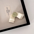 Detail of elegant cream satin bow with a soft green fabric camellia flower on a hair clip - Green Bow Hair Clip
