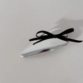 Dettaglio del fermaglio BB argento metallizzato con un piccolo fiocco di nastro nero - Triangolo Argento Fiocco Nero