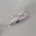 Dettaglio di un fermaglio per capelli in metallo argento con fiocco in nastro rosa - Triangolo Argento Fiocco Rosa