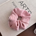 Rosa Satin-Haargummi mit weißen Wellenkanten auf einem Buchhintergrund zum Stylen - Rosa Gaze Kante Rosa Scrunchie