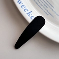 Gros plan sur une barrette BB classique en tissu noir posée sur une assiette en céramique - Pince à Cheveux Larme (4#) / Noir