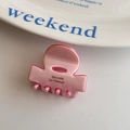 Detalle de pinza para el pelo de acetato rosa con texto Barrette La France en plato cerámico - Rosa