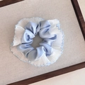 Detalle de coletero de malla azul claro con bordes plisados blancos en fondo neutro - Azul
