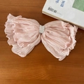 Pinza rosa para el pelo con volantes y perlas sobre un fondo de madera minimalista - Scrunchie Encaje Rosa Lazo Perla