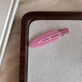Detailed close-up of a pink matte resin seamless hair clip on a wooden display stand - Light Pink