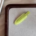 Detalle de la pinza para el cabello verde aguacate mate en un expositor minimalista - Beige