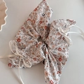 Dettaglio di scrunchie floreale arancione con pizzo bianco e decorazione a fiocco - Base Bianca Fiori Arancioni Doppio Fiocco