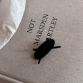 Nahaufnahme der schwarzen Schleifen-Haarspange auf Leinwandhintergrund im minimalistischen Stil - Schwarze Ovale Haarspange Mit Schwarzer Schleife
