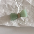 Detail of translucent green acetate bow hair clip on a white textured background - Green Bow Duckbill Clip