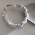 Dettaglio del cerchietto bianco con paillettes, texture arricciata e accenti brillanti - Stile Plissettato Bianco