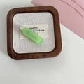 Matte pale green rectangular hair clip with silver metal grip on a wooden tray - Solid Green Hair Clip