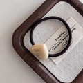Detailansicht des cremefarbenen Herzanhängers mit France Handmade Text auf braunem Gummi - Milchweißes Herz