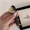 Detail of amber heart hair claw clip with brown spiral handle and glossy resin finish - Black Milk Tea